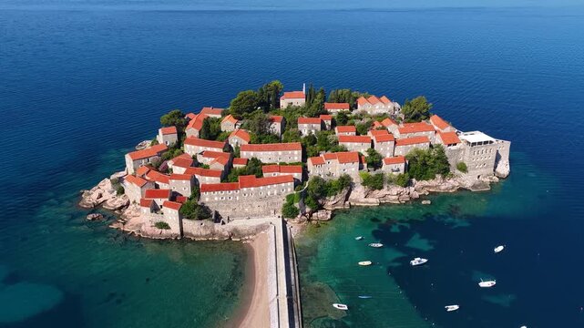 Aerial view of the island of St. Stefan on the Adriatic coast of Montenegro in Mediterranean Sea, showing the coastline and architecture. It is an island resort and popular summer vacation destination