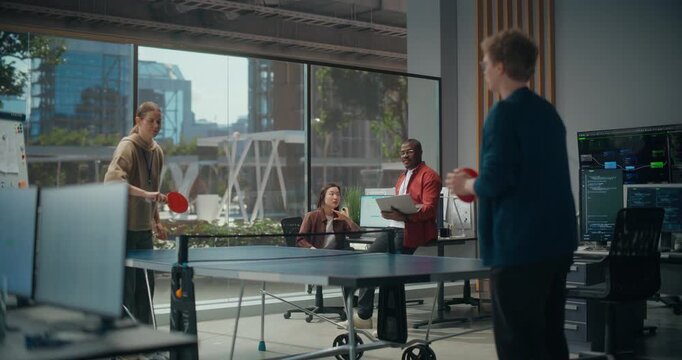 Tech Startup Coworkers Play a Game of Table Tennis Match Game in Office: Woman Serves to Male Engineer While Colleagues With Laptop Debate App. Slow Motion Fun