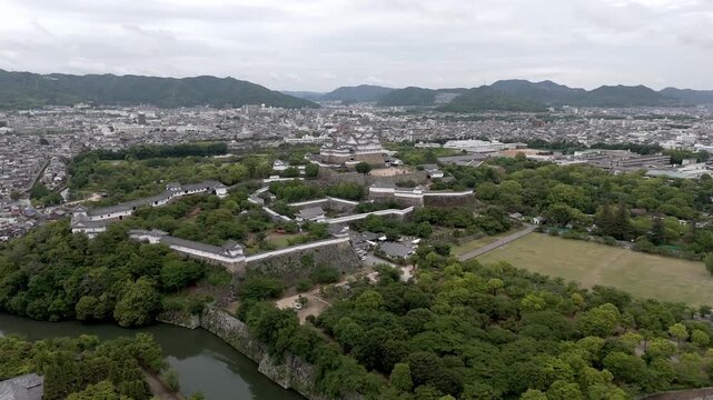 Aerial Flight Around Himeji Castle Above Historic Grounds and Urban Landscape in Hyogo Japan