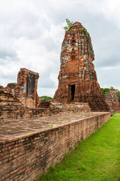 View of Weathered Brick Prangs and Temple Ruins on a Grassy Field at Ayutthaya