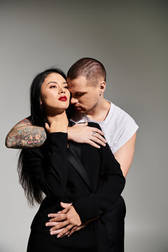 A beautiful young couple embraces in a trendy studio, showcasing their love and fashion.