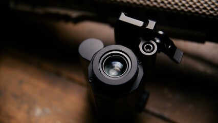 Obraz premium A close view of a black tactical scope attached to a textured metallic rail system on a rifle frame showing mounting hardware and lens housing components on a professional grade weapon
