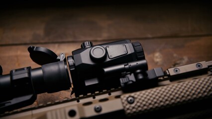 Obraz premium A side profile view of a tactical optic mounted on a tan textured rail platform highlighting the mechanical quick release lever and secure fastening hardware on professional weaponry