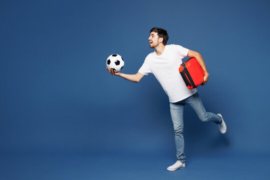 Traveler man wear white clothes cheer up support football sport team hold passport ticket soccer ball run isolated on plain blue background Tourist travel abroad in free time. Air flight trip concept.
