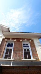 Low Angle View of a Traditional Red Brick House Facade Under a Clear Blue Sky © Belva
