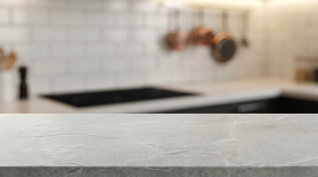 Gray stone kitchen counter surface mockup with blurred white subway tile backsplash and copper pans background.