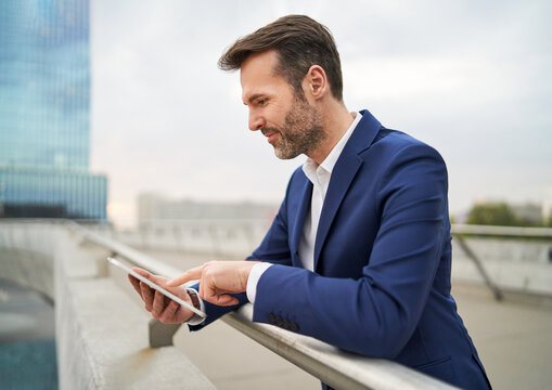 Businessman browsing digital tablet while in a city