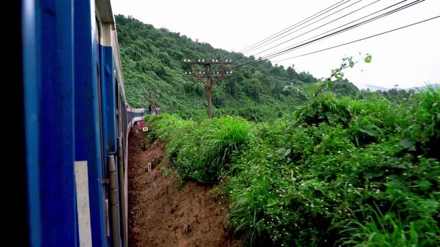 Traditional Blue and Red Train Traveling Through Scenic Vietnam Countryside Between Da Nang and Hue Landscape