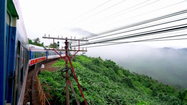 Traditional Blue and Red Train Traveling Through Scenic Vietnam Countryside Between Da Nang and Hue Landscape