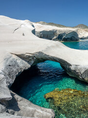 Naklejka premium Sarakiniko beach, or moon beach with a natural arch of white volcanic rocks and transparent water in Milos, Cyclades Islands, Greece