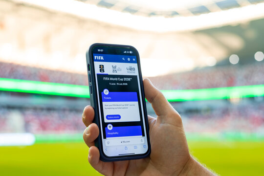 MINSK, BELARUS JUNE 9, 2026: Man holding a purple Apple iPhone 14 Pro in the stadium. The official FIFA website selling tickets for the 2026 FIFA World Cup in the USA, Mexico, Canada.