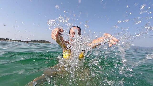 Smiling Woman Enjoying splashing water in camera in clear ocean turquoise waters