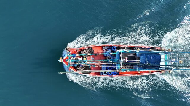 fishing boat traveling at high speed across the deep blue ocean, leaving a prominent white wake behind, representing maritime industry, fishery, and fast transport.