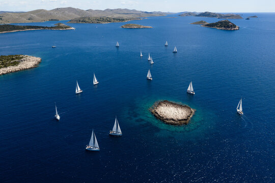 Aerial view of yachts regatta sailing around the rocky Taljuric islet in Telascica Nature Park, Croatia