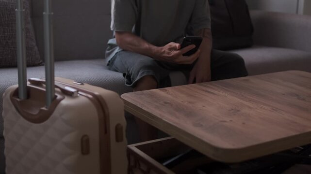 Checking phone alone in temporary apartment, expat lifestyle, distance from home and search for connection while living between destinations