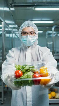 Food Safety Worker Presents Fresh Produce in Controlled Environment &ndash; Quality Assurance and Hygienic Farming Practices