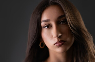 Naklejka premium Young woman posing in studio, showcasing beauty and fashion