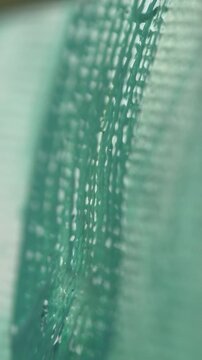 A close-up of a brush bristling with green paint on a canvas leaving brushstrokes of oil paint on a white canvas. The artist is making the first brushstrokes of the paint