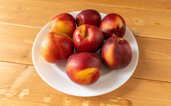 Fresh ripe nectarines arranging on a white plate