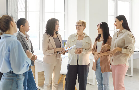 Women team meeting discussion mentoring planning leadership. They share updates in a bright office, encouraging collaboration and clear communication. Teamwork and professional growth concept.