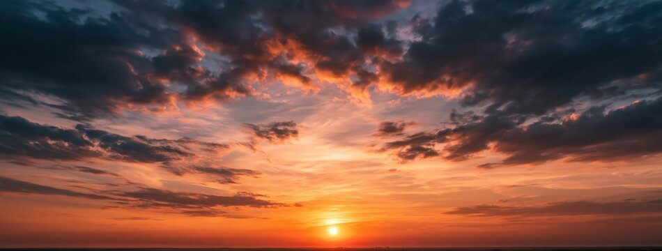Sunset over a dramatic horizon with vibrant purple and orange clouds in the sky
