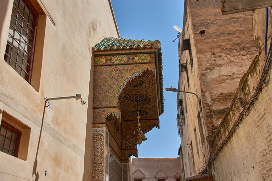Traditional zellige mosaics decorate the carved wooden porch of the mystical Zawiya of Sidi Ahmed al-Tijani.