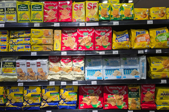 Bayan Lepas, Malaysia - May 14, 2026: A variety of packaged cream crackers and soda biscuits, including Hup Seng and Jacob's, on shelves at a Mercato grocery store aisle.