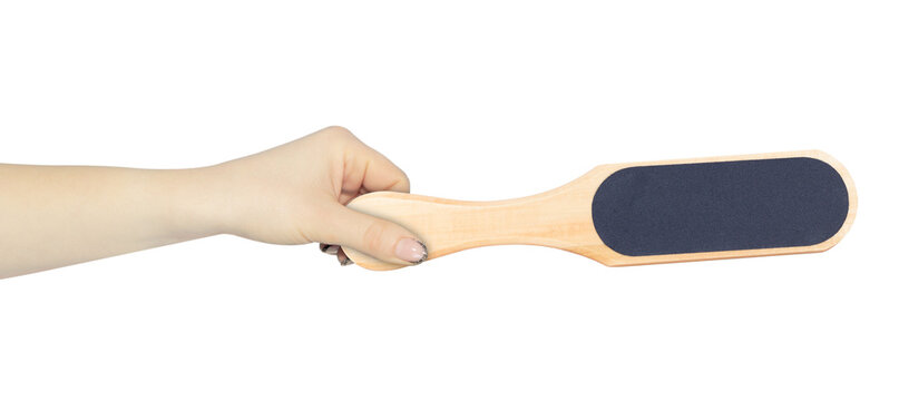 Brushes and files for feet in hand, outstretched hand with pumice stone for the treatment of feet from calluses, isolated from background