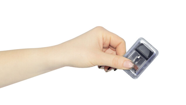 New vape cartridge in a packaging box in hand, outstretched hand with vape cartridge isolated on background