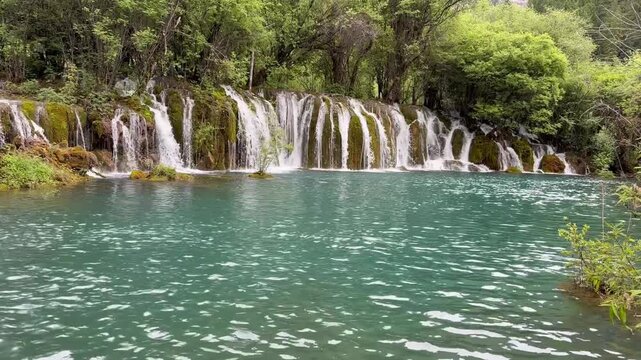 Majestic multi-tiered waterfall in Jiuzhaigou Valley UNESCO World Heritage Site, Sichuan, China &ndash; crystal clear water, in a gloomy day, in June, summer
