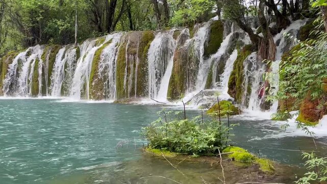 Majestic multi-tiered waterfall in Jiuzhaigou Valley UNESCO World Heritage Site, Sichuan, China &ndash; crystal clear water, in a gloomy day, in June, summer