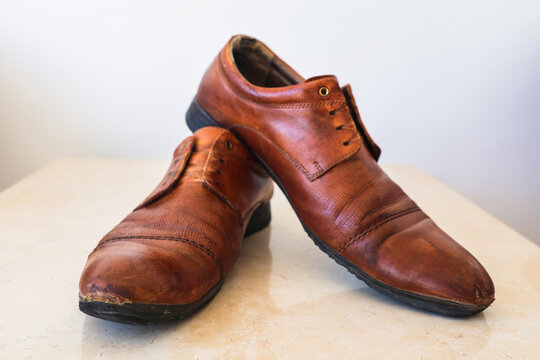 Worn-out old leather men's shoes that have served their time showing years of use and character.