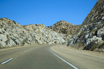 Fototapeta premium Westbound climb on Interstate 8 through rugged Imperial county canyon with dramatic rock walls and open copy space
