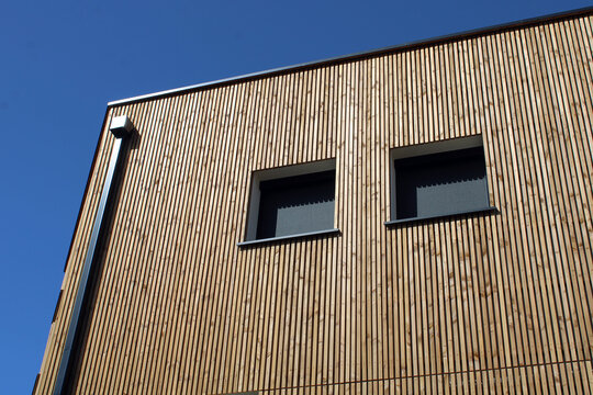 B&acirc;timent &agrave; l&rsquo;esth&eacute;tique contemporaine avec bardage bois vertical et store de fen&ecirc;tre enrouleur occultant en toile tissu noir