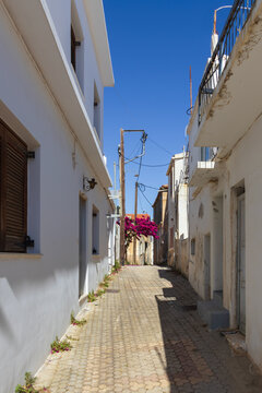 Charming narrow alleyway with traditional rustic architecture and stone houses in the historic village of Gouves, Crete, Greece