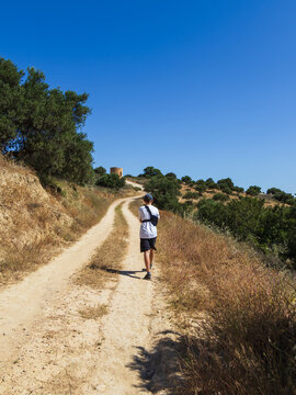 Brave 11 year old boy wearing an arm brace walking on a path towards the Gournes Gouvon viewpoint during a summer vacation in Crete, Greece