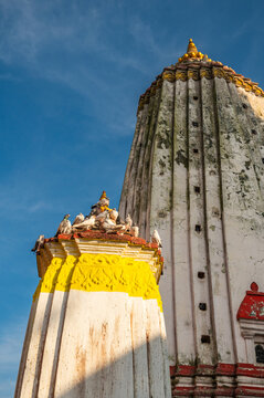 Ancient Buddhist Swayambhu temple architecture against blue sky, Kathmandu landmark.