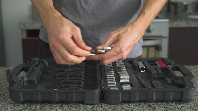 Close up man placing set of wrenches into toolbox with clear sound. Hands organizing spanners in case. Repair work, tool storage, maintenance and ASMR concept.