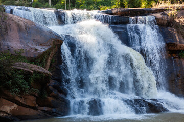 Tat Huang Waterfall in Phu Suan Sai National Park, Thailand. Powerful cascades flow over rocky terrain. Lush greenery surrounds the scenic waterfall. © Eugene Ga
