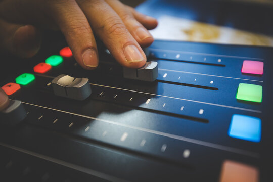 Hand Operating Faders on a Professional Audio Mixing Console