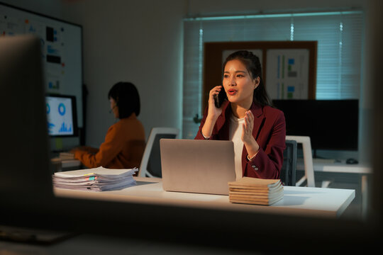 Business woman talking on phone working late at night