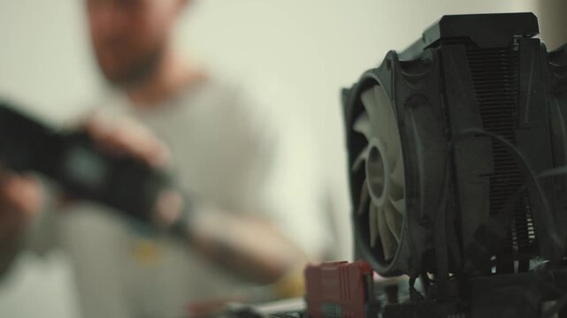 Computer technician cleaning pc components with air blower