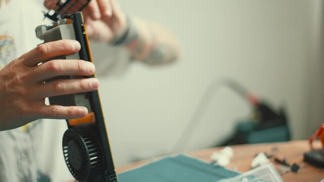 Computer technician assembling graphics card fan