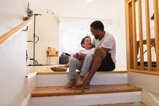 Happy father and son bonding on home wooden steps