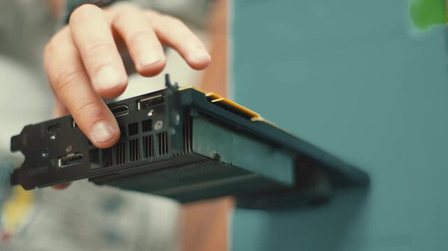 Technician assembling computer graphics card component