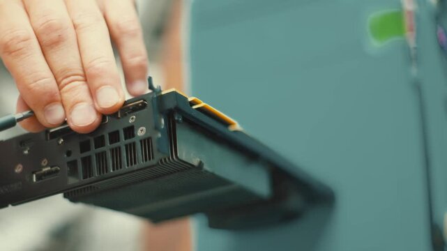 Technician inserting video graphics card into computer