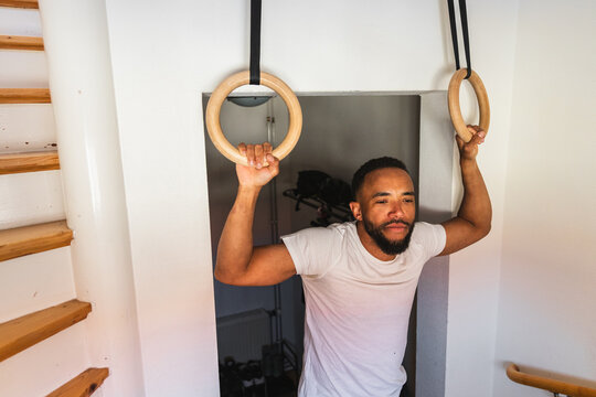 Man preparing to use wooden gymnastics rings at home