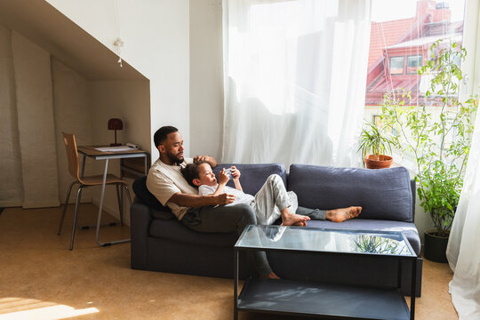 Authentic family moment of father and son on couch