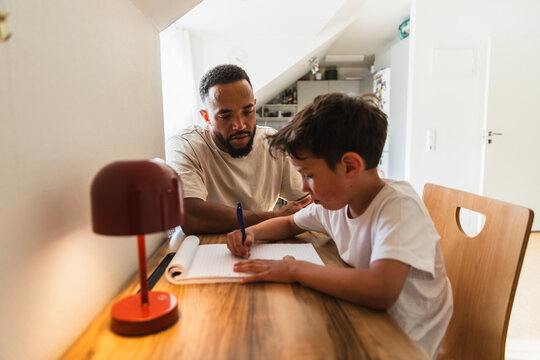 Supportive father helping son with school homework