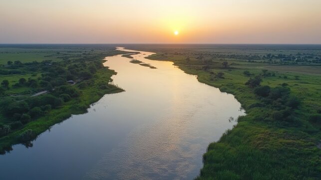 A Magnificent Sunset Paints the Sky with Golden Hues Over a Winding River Creating Stunning Reflections